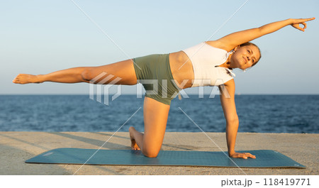 Various yoga poses performed by a sporty girl on sunny seaside Various yoga poses performed by a sporty girl on sunny seaside 118419771