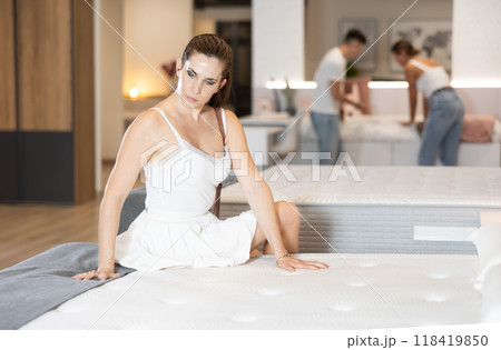 Adult woman chooses mattress in store 118419850