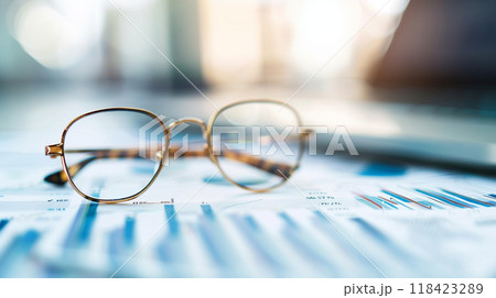 A pair of glasses sits on a blue piece of paper with a bunch of numbers on it 118423289