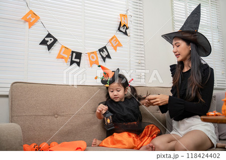Mother and Daughter Celebrating Halloween at Home with Costumes and Decorations Mother and Daughter Celebrating Halloween at Home with Costumes and Decorations 118424402