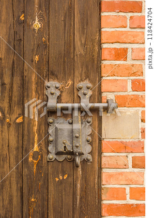 Close-up view of an ancient door key lock on an old wooden door. High quality photo 118424704