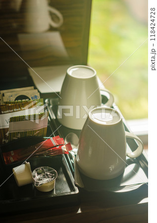 two white cups, some tea bags and coffee on the coffee table in hotel room . High quality photo 118424728