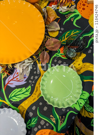 green and orange and white plates on colourful tablecloth and green glass . High quality photo green and orange and white plates on colourful tablecloth and green glass . High quality photo 118424746