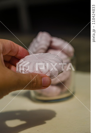 women hand holds pink marshmallows and more marshmallows on background in cup . High quality photo women hand holds pink marshmallows and more marshmallows on background in cup . High quality photo 118424833