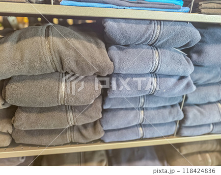 mens black and blue fleece jackets in stack in the shop . High quality photo mens black and blue fleece jackets in stack in the shop . High quality photo 118424836