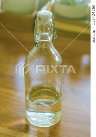 Bottle with a clear liquid, vinegar in the kitchen . High quality photo Bottle with a clear liquid, vinegar in the kitchen . High quality photo 118424860