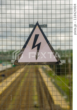 On the grid of the fence weighs sign.It warns of high voltage electricity. High quality photo On the grid of the fence weighs sign.It warns of high voltage electricity. High quality photo 118424904