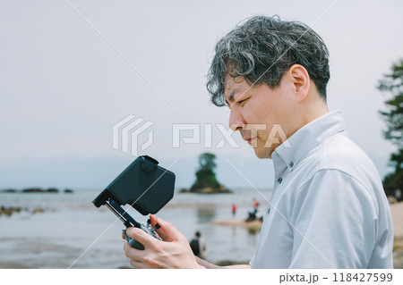 海岸でドローンを飛ばす男性 海岸でドローンを飛ばす男性 118427599