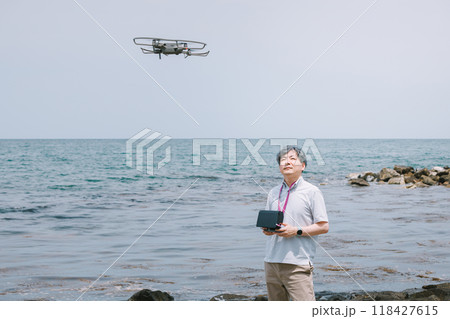 海岸でドローンを飛ばす男性 118427615