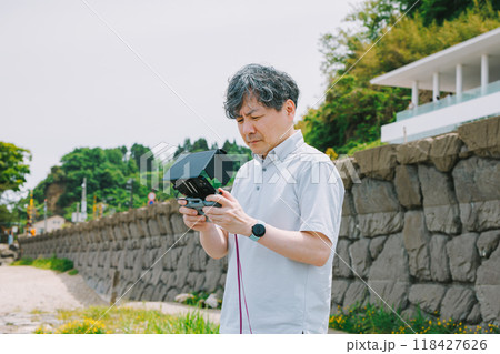 海岸でドローンを飛ばす男性 海岸でドローンを飛ばす男性 118427626