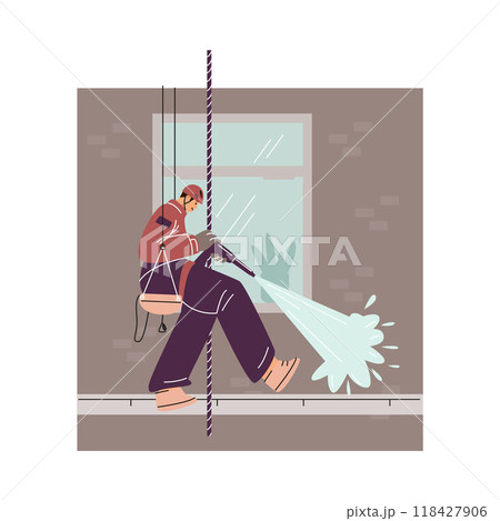 An industrial climber on a safety rope using a hose washes away dirt from the wall of a building. 118427906