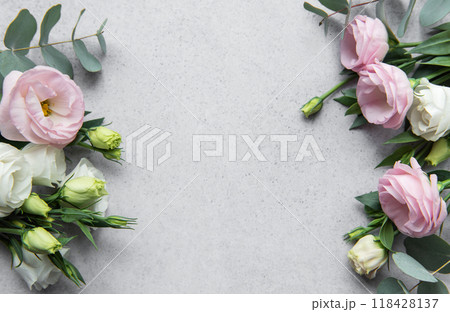 Delicate arrangement of mixed flowers and eucalyptus leaves on a light grey surface Delicate arrangement of mixed flowers and eucalyptus leaves on a light grey surface 118428137