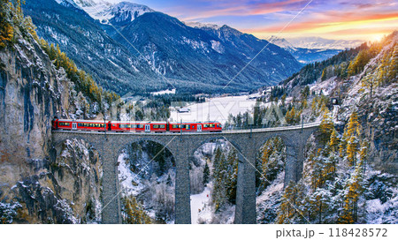Aerial view of Train passing through famous mountain in Filisur, Switzerland. Landwasser Viaduct world heritage with train express in Swiss Alps snow winter scenery. 118428572