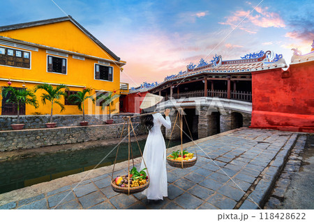 Asian woman wearing vietnam culture traditional and sell the fruit on the street, Hoi an in Vietnam. Asian woman wearing vietnam culture traditional and sell the fruit on the street, Hoi an in Vietnam. 118428622