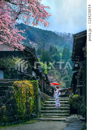 Old town of Tsumago juku in spring. Asian woman wearing japanese traditional kimono at Tsumago juku in Nagano, Japan. Old town of Tsumago juku in spring. Asian woman wearing japanese traditional kimono at Tsumago juku in Nagano, Japan. 118428654