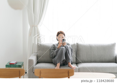 ソファーに座ってスマホをする女性 118428680