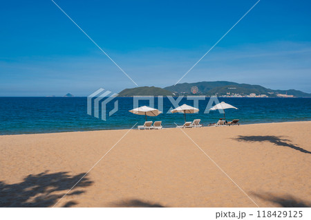 beach umbrellas with sun loungers without people on a sandy beach against the background of the sea 118429125