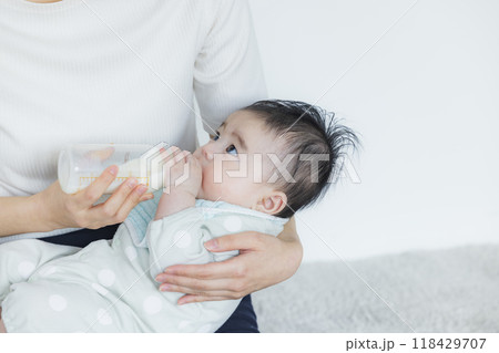 赤ちゃんにミルクをあげる女性　 118429707