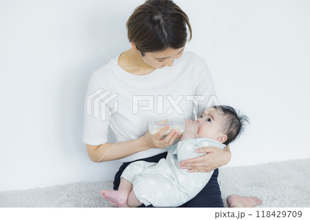赤ちゃんにミルクをあげる女性　 118429709
