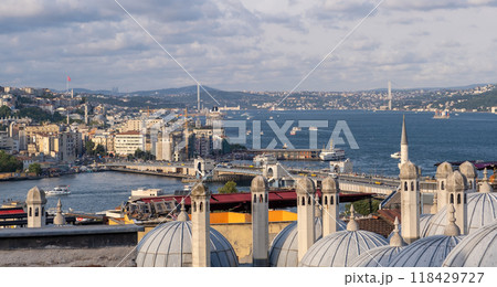 The skyline of Istanbul along the Bosphorus strait reveals vibrant neighborhoods and domed rooftops under a clear blue sky. 118429727