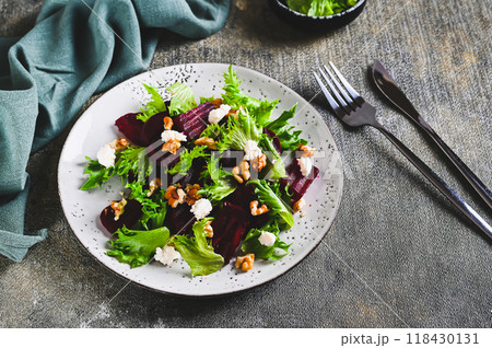 Beetroot salad with cheese, nuts and herbs on a plate on the table 118430131