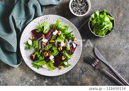 Delicious salad of beetroot, lettuce, nuts and ricotta on a plate on the table top view Delicious salad of beetroot, lettuce, nuts and ricotta on a plate on the table top view 118430134