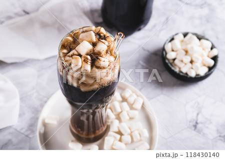 Refreshing fluffy coke with marshmallow in a glass on the table 118430140