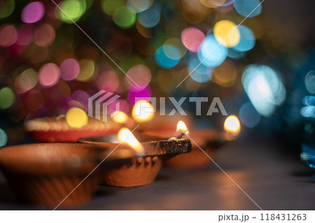 Diwali diya lamp over colourful bokeh background, Indian festival of lights. Diwali diya lamp over colourful bokeh background, Indian festival of lights. 118431263