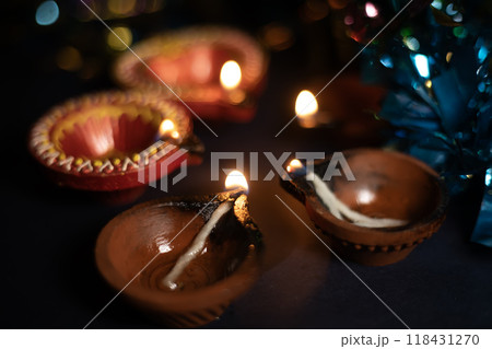 Glowing clay lamps during Indian festival Diwali celebrations on black background. Glowing clay lamps during Indian festival Diwali celebrations on black background. 118431270
