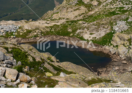 Hidden mountain lake surrounded by rocky terrain in alpine landscape 118431665