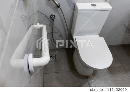 Hand rail fixture on wall inside wc next to toilet bowl to aid users with physical health mobility issue Hand rail fixture on wall inside wc next to toilet bowl to aid users with physical health mobility issue 118432069