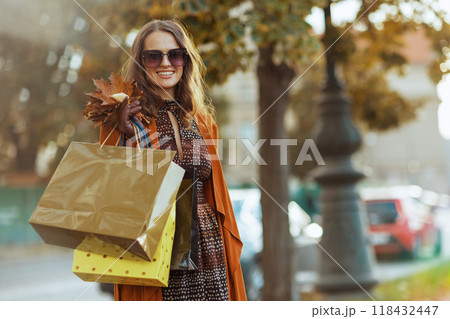 happy elegant woman in brown trench coat 118432447