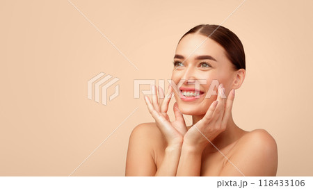 Face Skincare Delight. Cheerful Young Woman Smiling Touching Smooth And Soft Skin, Caring For Facial Beauty Looking Aside Posing Shirtless On Light Gray Studio Background. Panorama With Copy Space Face Skincare Delight. Cheerful Young Woman Smiling Touching Smooth And Soft Skin, Caring For Facial Beauty Looking Aside Posing Shirtless On Light Gray Studio Background. Panorama With Copy Space 118433106