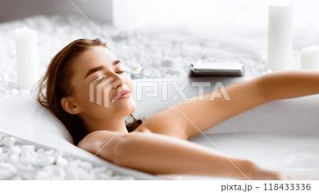 Woman Enjoying Milky Bath After Work Day, Lying With Closed Eyes Woman Enjoying Milky Bath After Work Day, Lying With Closed Eyes 118433336