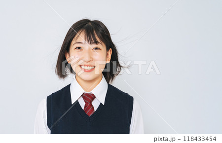 風に髪をなびかせる制服を着た女子学生 118433454