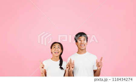 Happy students pointing and looking up on copy space, pink background Happy students pointing and looking up on copy space, pink background 118434274