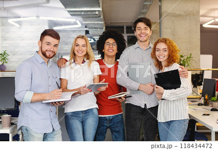 Successful creative business team looking at camera and smiling. Diverse people standing together at startup. Successful creative business team looking at camera and smiling. Diverse people standing together at startup. 118434472