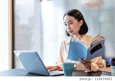 資料を片手にパソコンを操作している女性 118434801