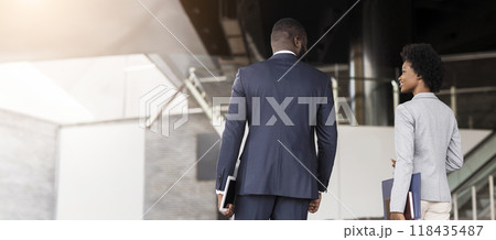 Happy african business partners leaving office building after successful meeting, side view Happy african business partners leaving office building after successful meeting, side view 118435487