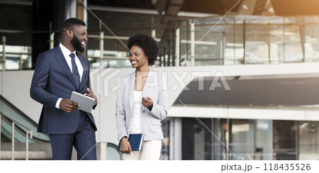 Happy african business partners leaving office building after successful meeting, cope space Happy african business partners leaving office building after successful meeting, cope space 118435526