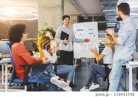 New marketing strategy. Young millennial team analyzing information on graphs and charts on whiteboard in office, free space New marketing strategy. Young millennial team analyzing information on graphs and charts on whiteboard in office, free space 118435598