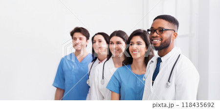 Team of doctors and interns standing in hospital in row and looking aside 118435692