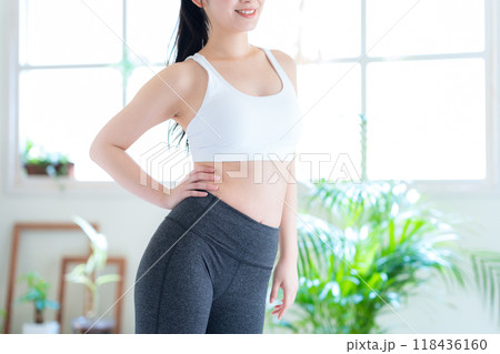 リビングでダイエットをする若い女性 リビングでダイエットをする若い女性 118436160