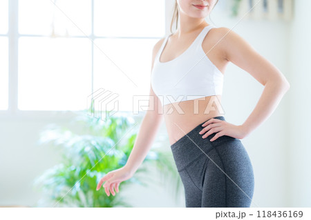 リビングでダイエットをする若い女性 リビングでダイエットをする若い女性 118436169