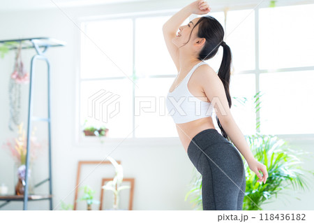 リビングでダイエットをする若い女性 リビングでダイエットをする若い女性 118436182