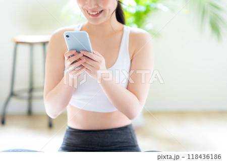 リビングでダイエットをする若い女性 リビングでダイエットをする若い女性 118436186