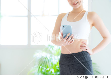 リビングでダイエットをする若い女性 リビングでダイエットをする若い女性 118436191