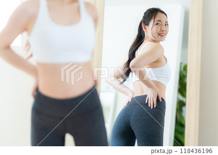 リビングでダイエットをする若い女性 リビングでダイエットをする若い女性 118436196