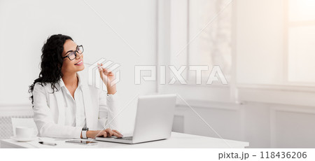 Thinking About Vacation. Happy hispanic businesswoman dreaming about holidays working at office, copyspace 118436206