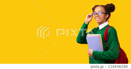 Happy Teenager. Portrait of half turned black girl wearing glasses and backpack, holding notebooks. Panorama, copyspace 118436280